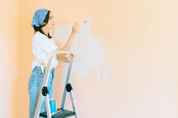Interior painting in Salem: painter on a stepladder rolling a wall